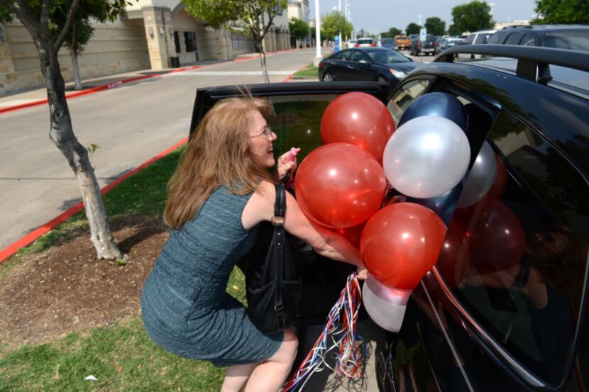 Laura Vanderpoel, a resident of Plantation Springs, stuffs balloons into the her car for her...