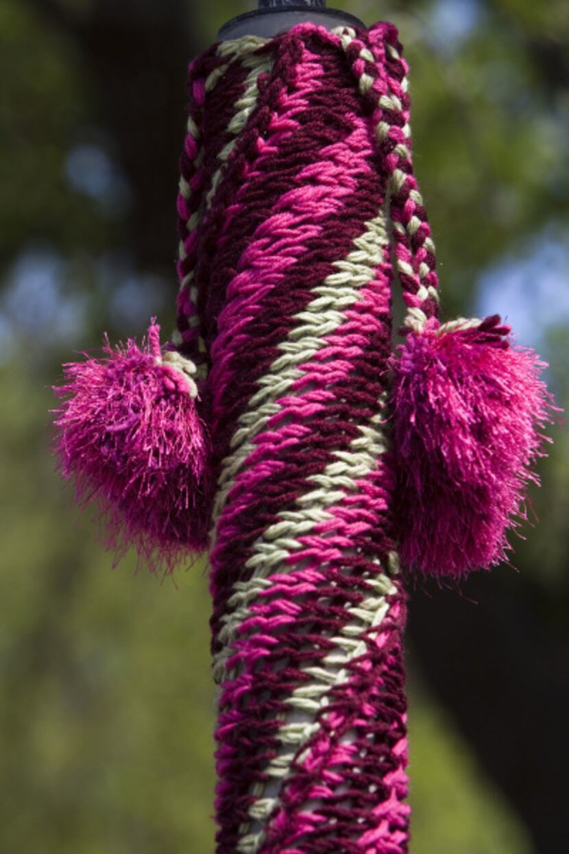 Yarn bombers use leftover or sturdy acrylic yarn for their craft. This pole near the...