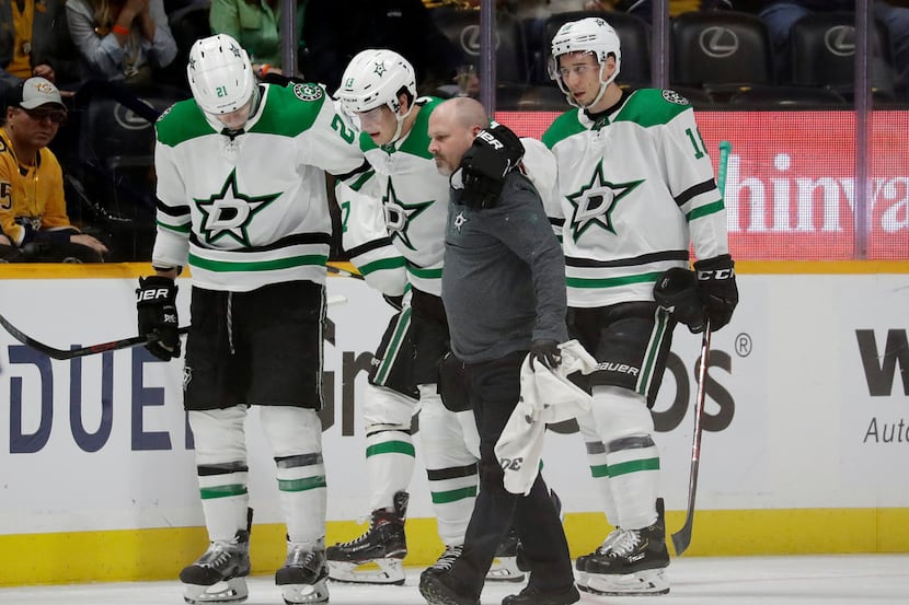 Dallas Stars center Mattias Janmark (13), of Sweden, is helped off the ice after being...