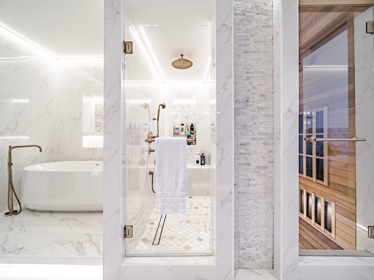 This serene bathroom includes a tub, rain shower and walk-in sauna.