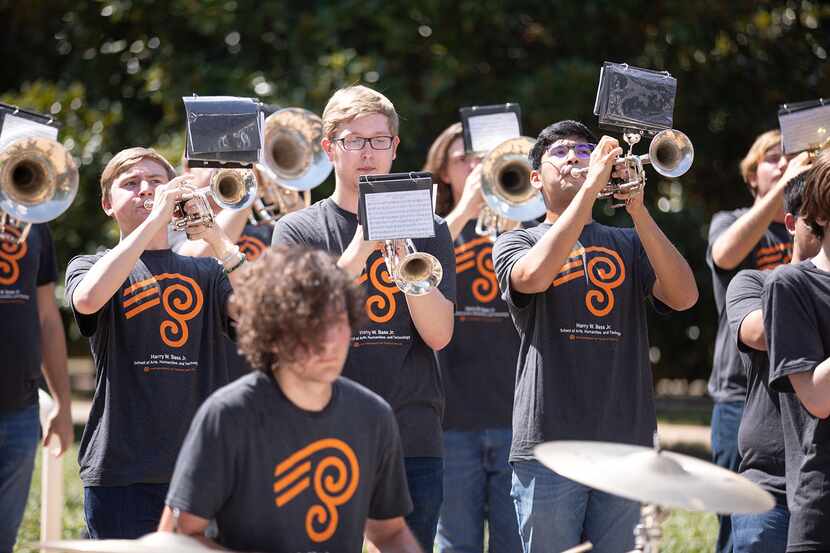 Students in black T-shirts play trombones in the UT Dallas Pep Band.
