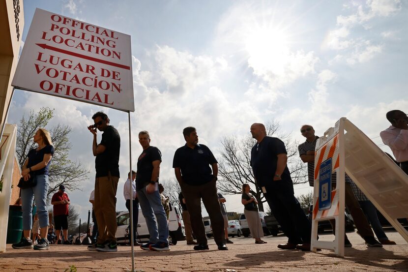 Voters line up at a polling site to vote in the state's primary election at Allen Municipal...