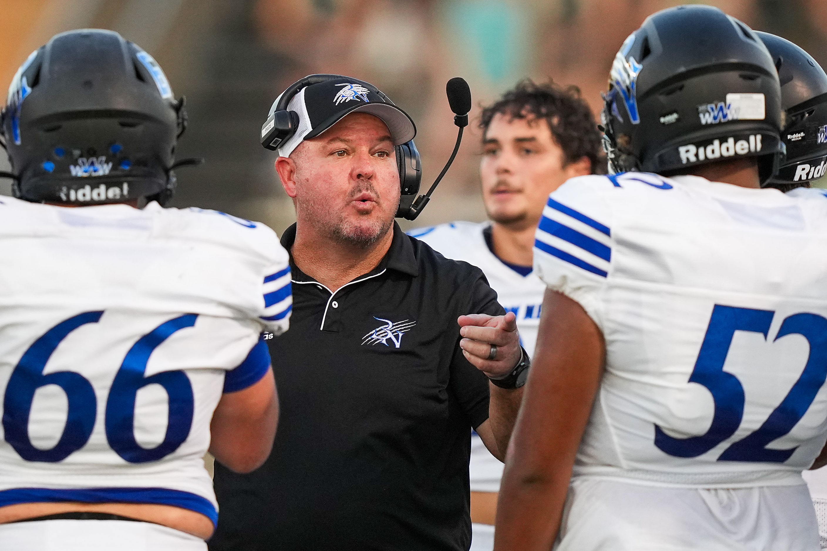 Trophy Club Byron Nelson head coach Travis Pride talks with Lucas Dempsey (66) and Adam...