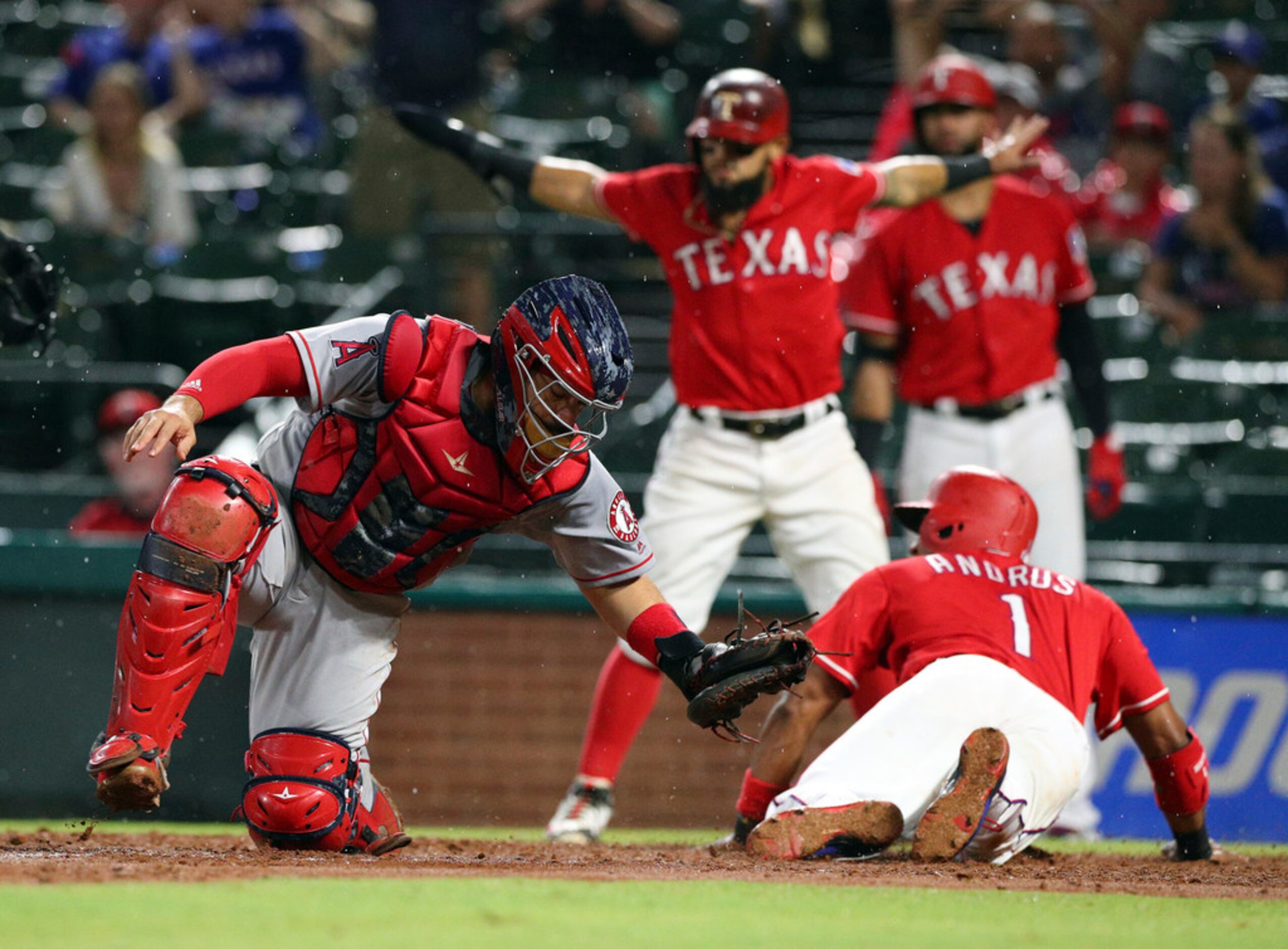 Los Angeles Angels catcher Rene Rivera (44) is late on the tag as Texas Rangers' Elvis...