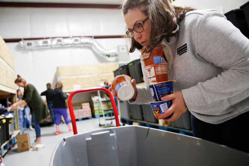 Volunteer Michelle McLemore organizes donated food items before assembling meals for...
