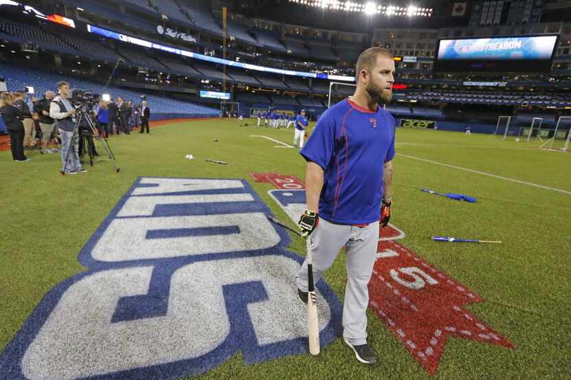 Texas Rangers first baseman Mike Napoli (25) walks across the ALDS logo after taking batting...