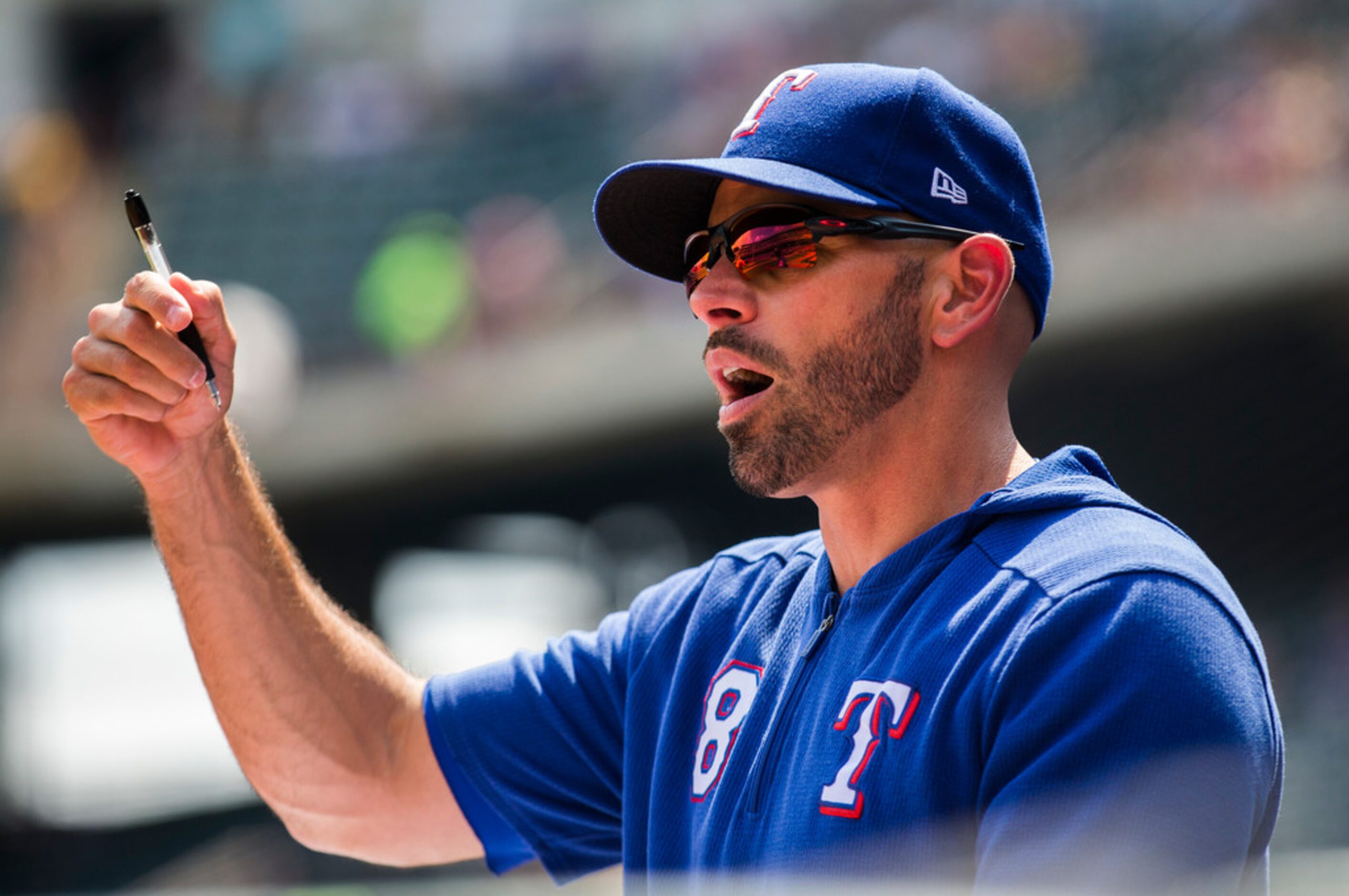 Texas Rangers manager Chris Woodward (8) gives instructions in the dugout during the first...