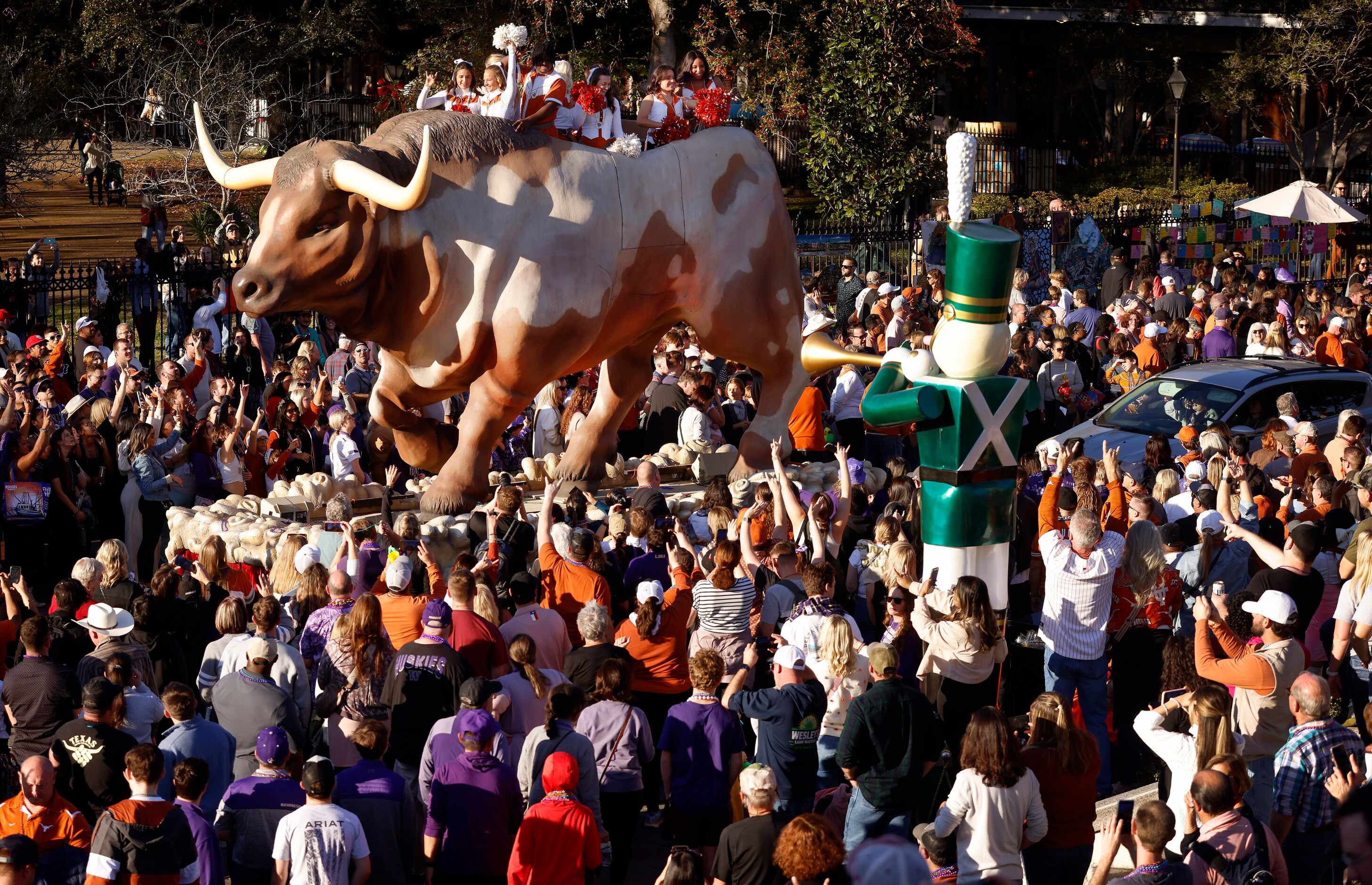 Texas Longhorns cheerleaders ride atop a large longhorn float during the Mardi Gras-style...
