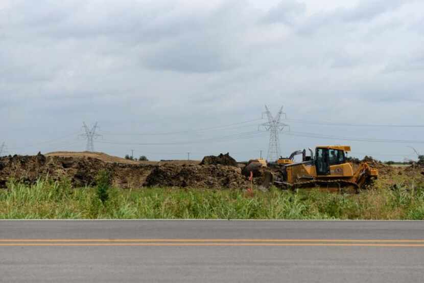 
Construction workers move dirt for a 1,400-home development called Inspiration.
