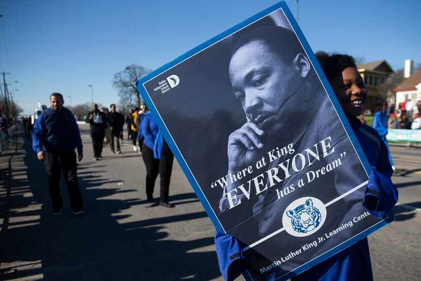 A student with the Martin Luther King JR. Learning Center holds a photo of MLK in the 38th...