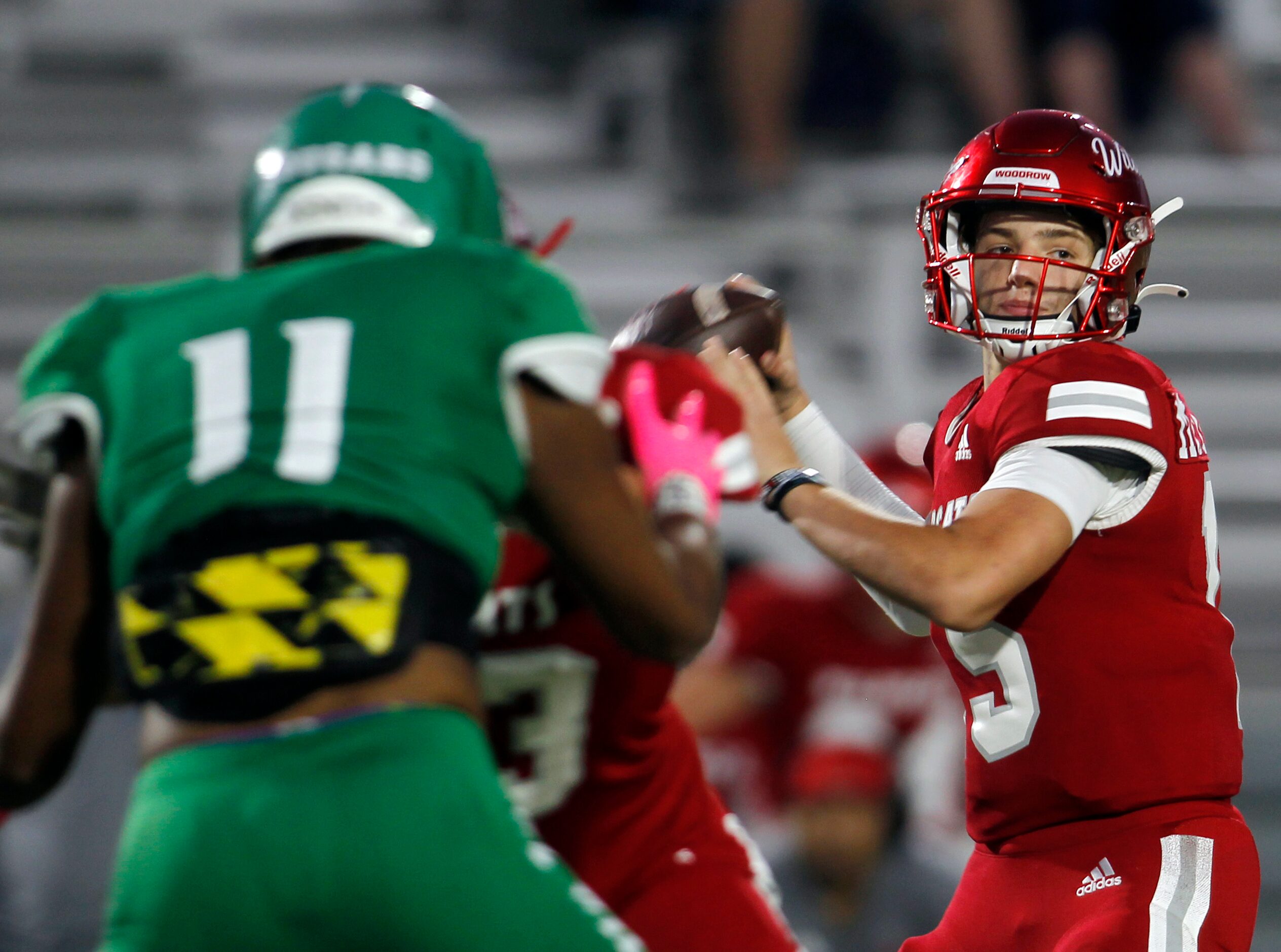 Dallas Woodrow Wilson quarterback Cam McGuire (15) looks to pass as Dallas Bryan Adams...