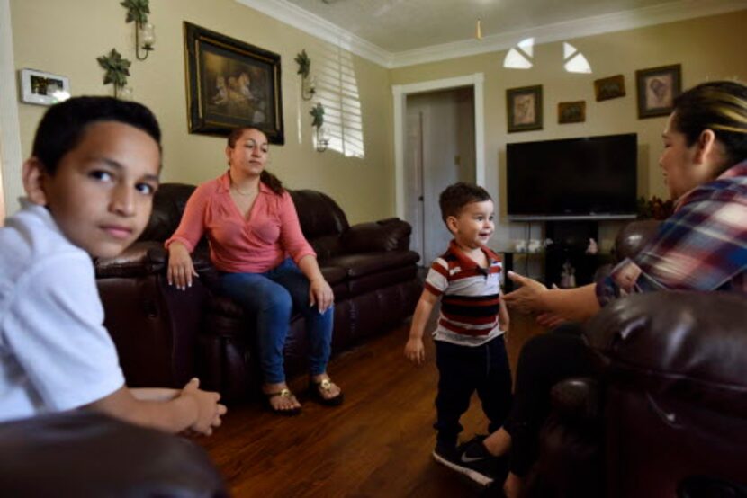 César (izq.) y su mamá Marta Hernández en la sala de la casa familiar en Irving. Hernández...