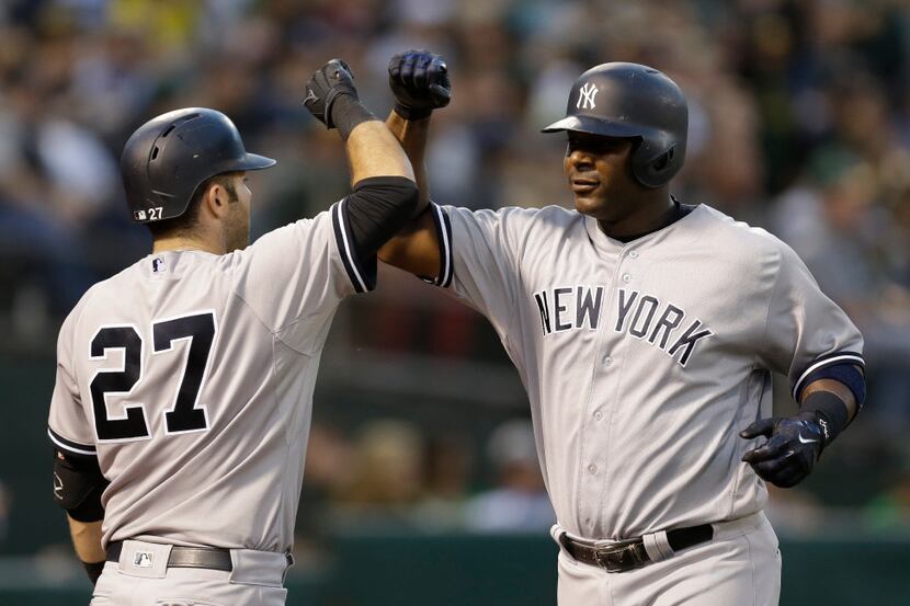 New York Yankees' Chris Carter, right, celebrates with Austin Romine (27) after hitting a...