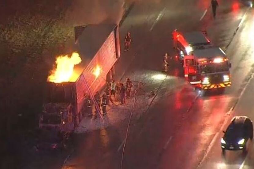 Flames shoot from the top of an 18-wheeler that caught fire Thursday morning in southwest...