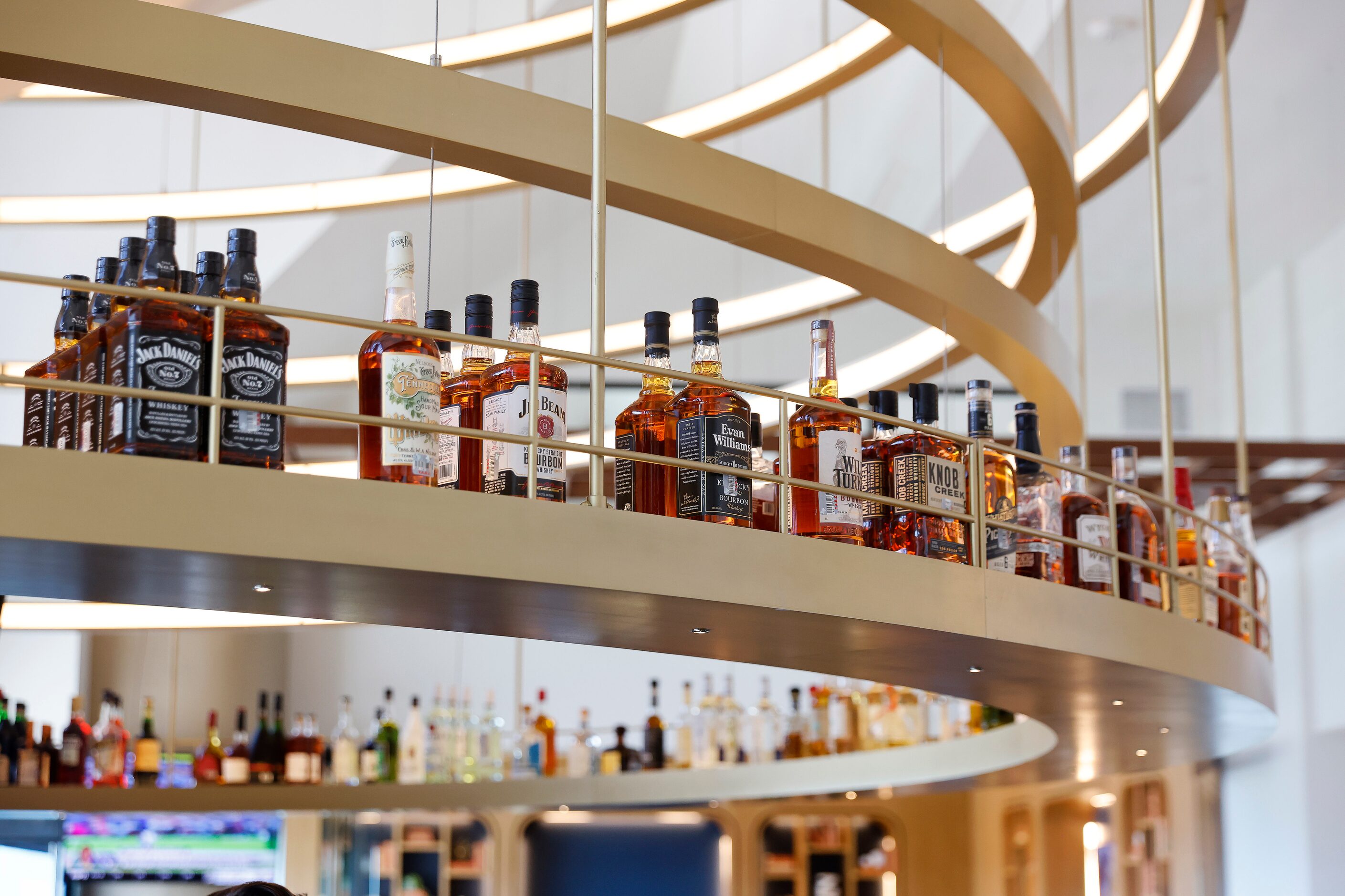 A looping shelf holds bolds of liquor inside the restyled mid-century modern Constellation...