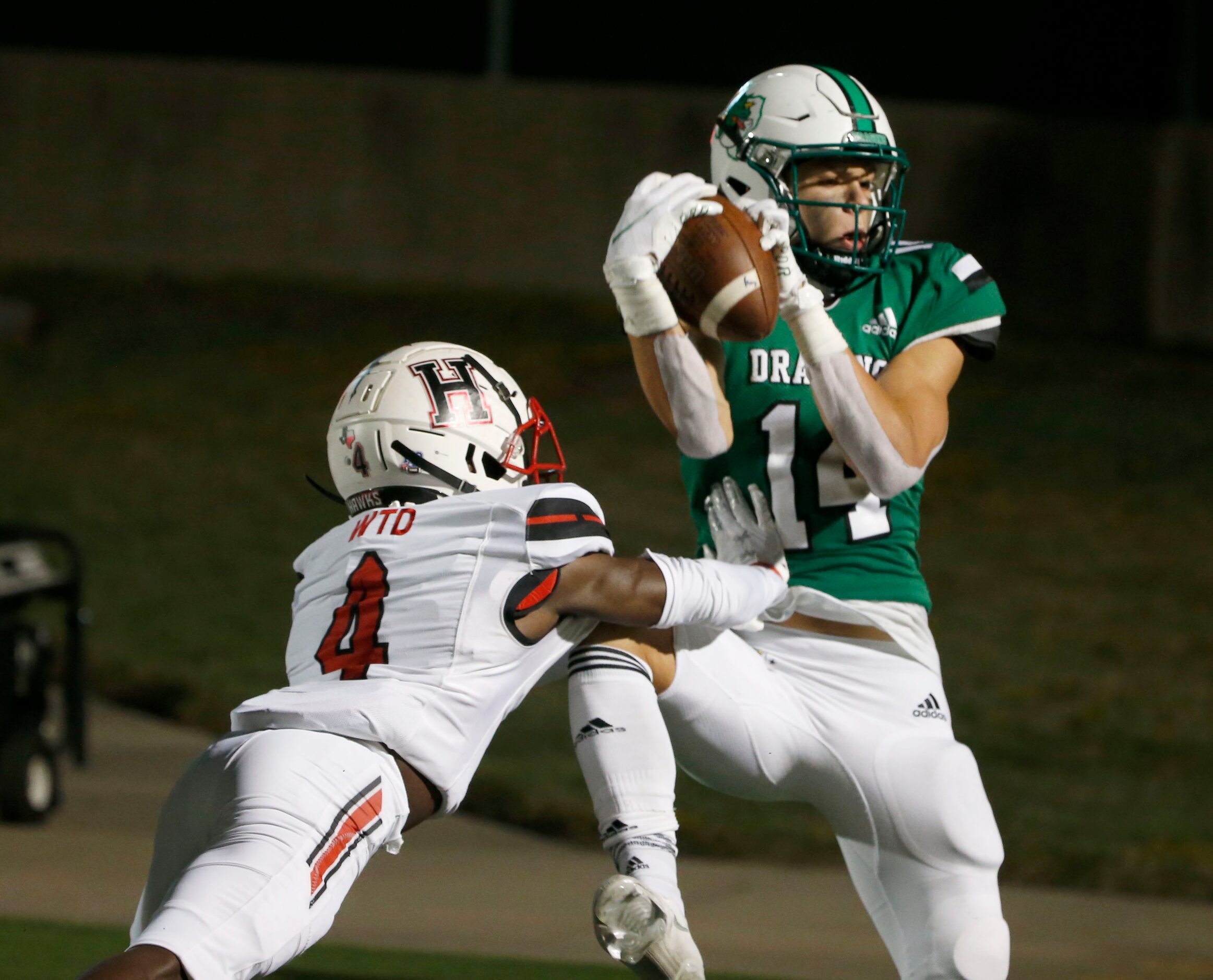 Southlake Carroll’s Brady Boyd (14) gets pushed by Rockwall Heath defender Dezmon Mims (4)...