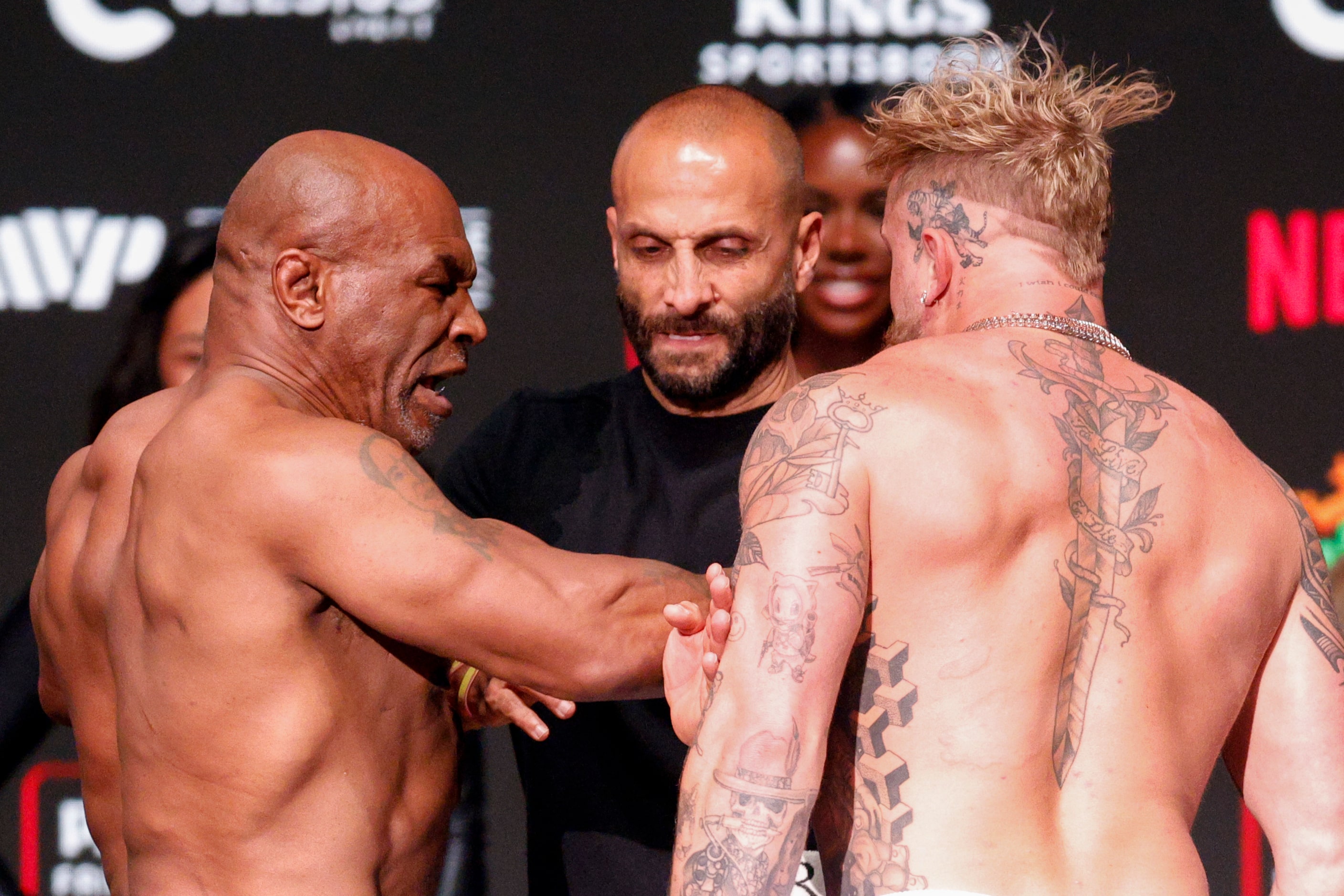 Mike Tyson slaps Jake Paul as they face-off during public weigh-ins ahead of their boxing...