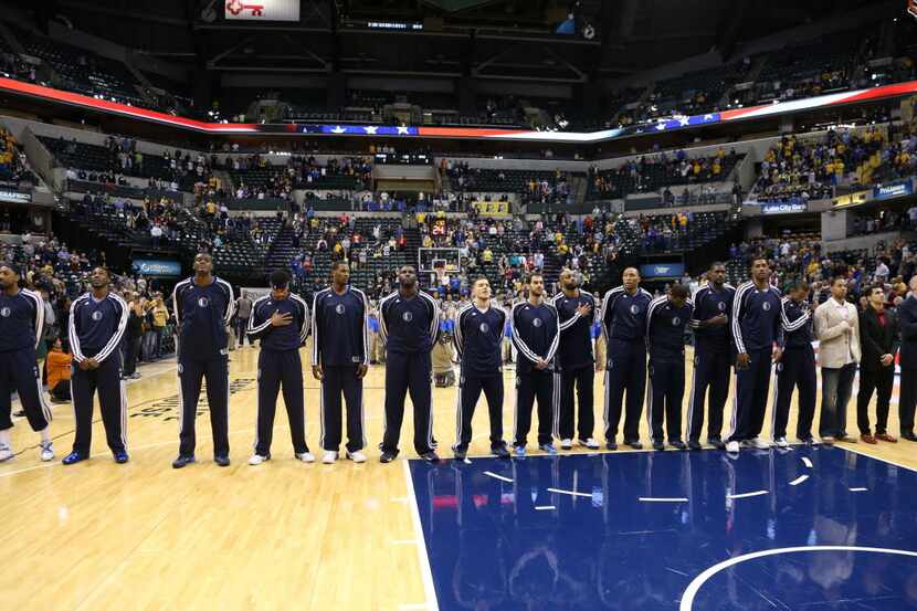 Dallas Mavericks line up for the playing of the National Anthem before the game against the...