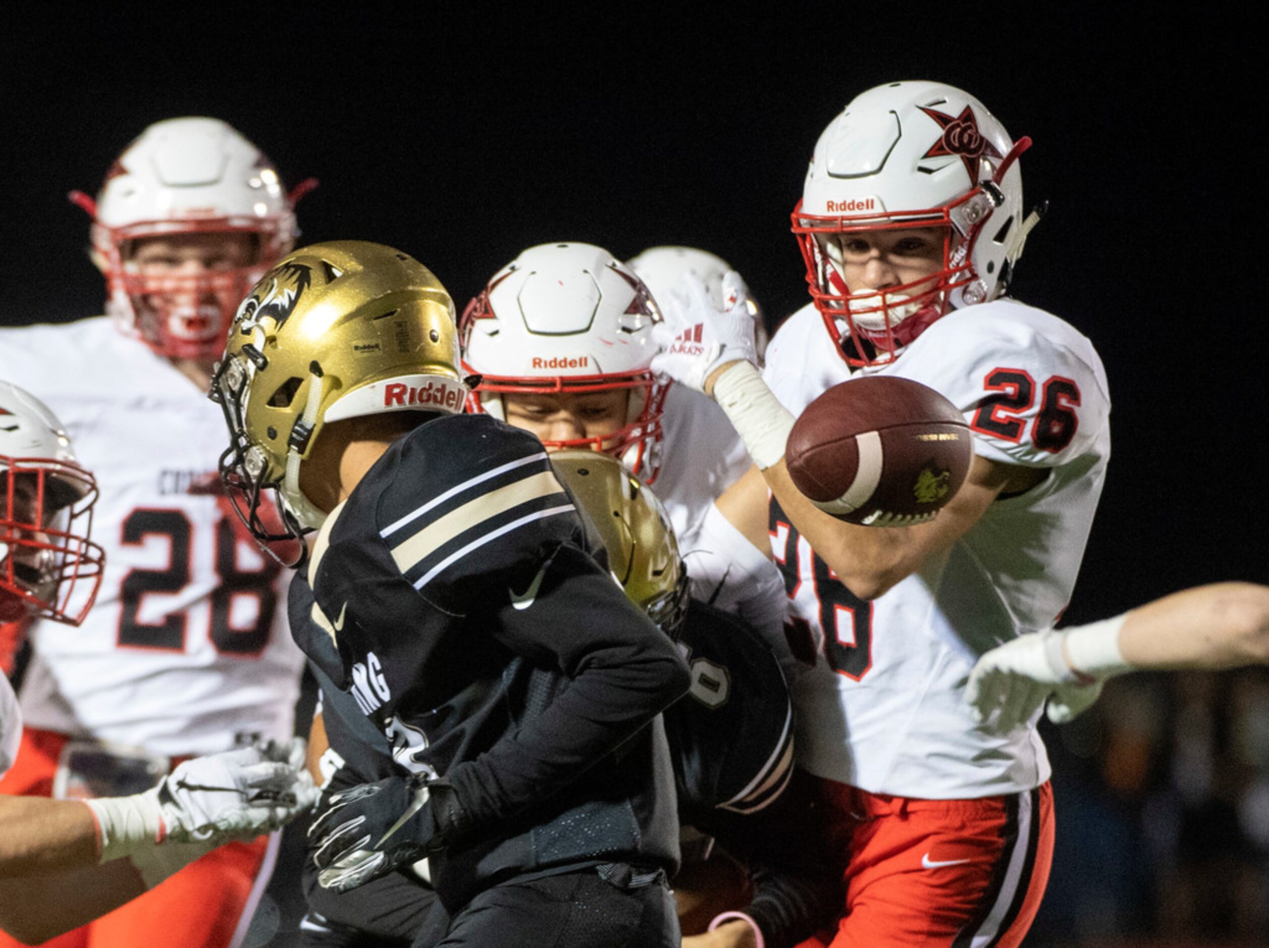 Coppell senior defensive back Noah Snelson (26) strips the ball from Irving senior wide...