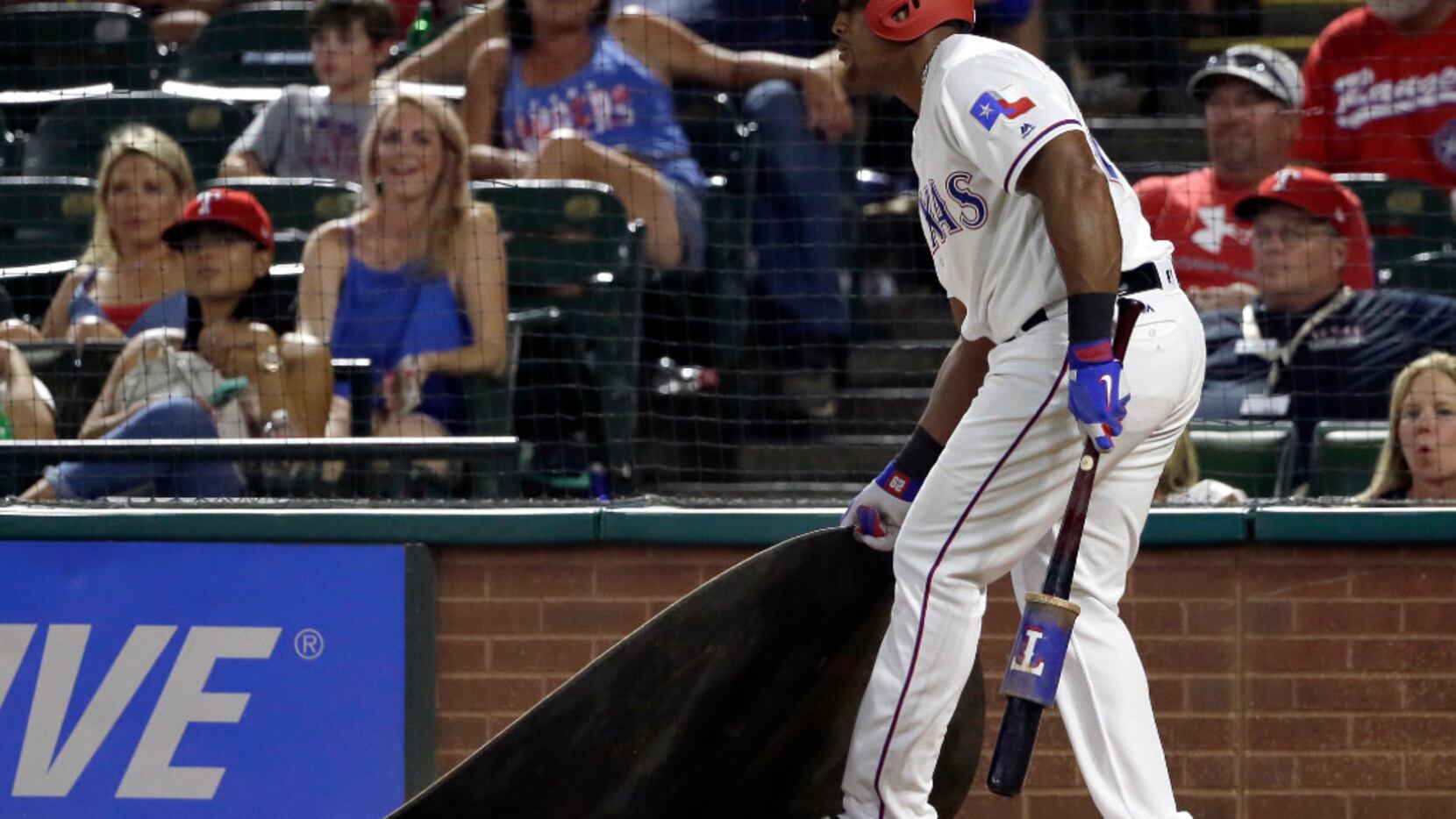 Texas Rangers' Adrian Beltre drags the on deck circle toward himself after being told by tje...