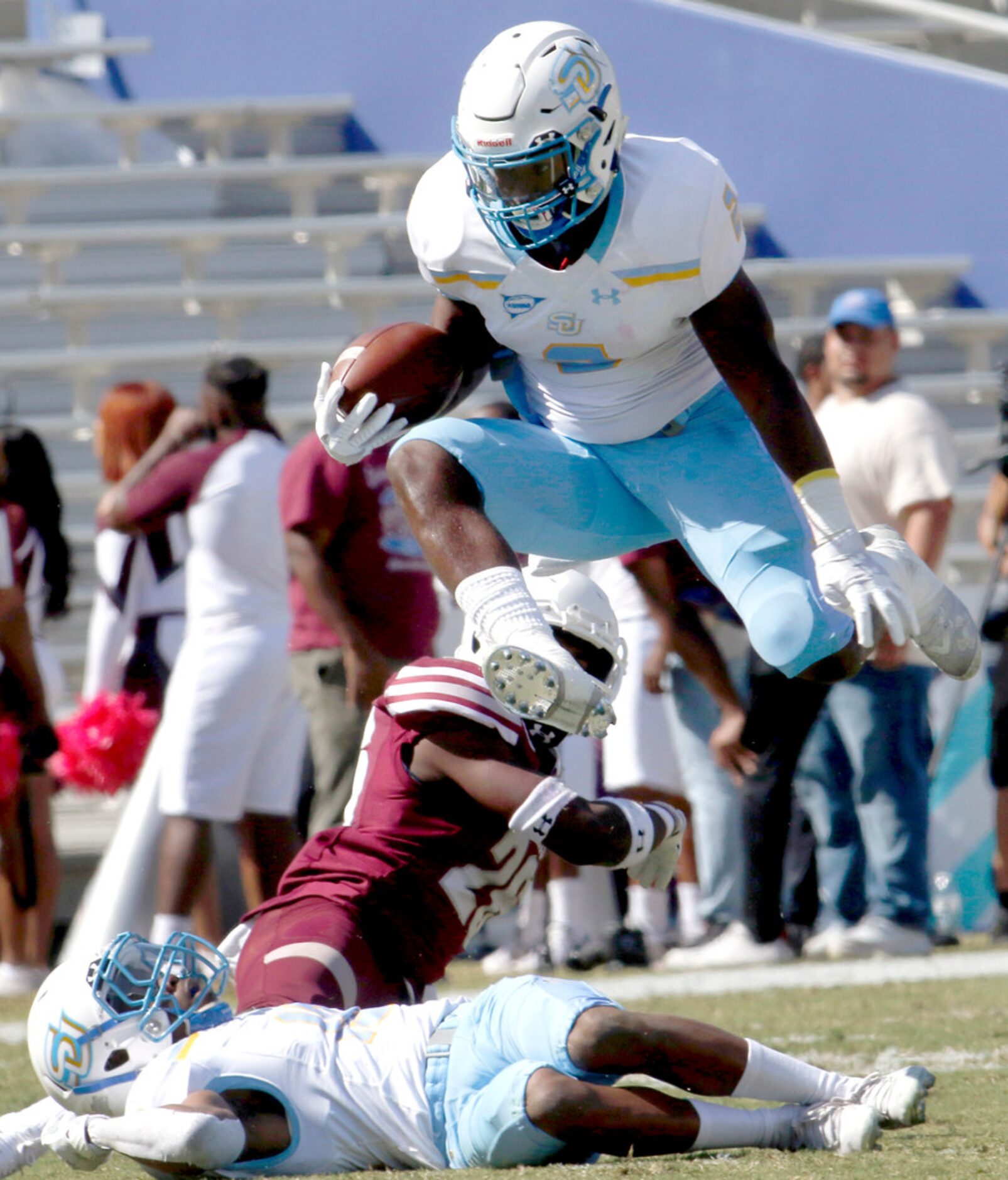 Southern running back Devon Benn (2) leaps to avoid players as he rambles deep into the...