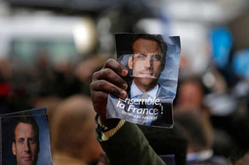 Unos partidistas del candidato francés independista, Emmanuel Macron, levantan su foto en...