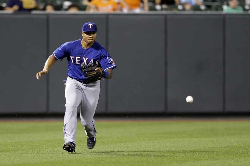 Texas Rangers left fielder Michael Choice fields a fly ball hit by Baltimore Orioles' Adam...