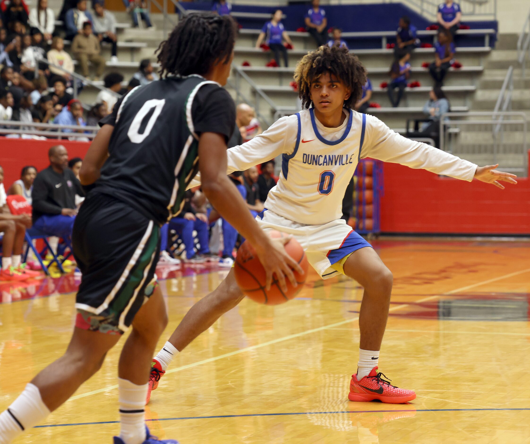 Duncanville guard Beckham Black (0), background, covers DeSoto guard Miles Pitt during first...