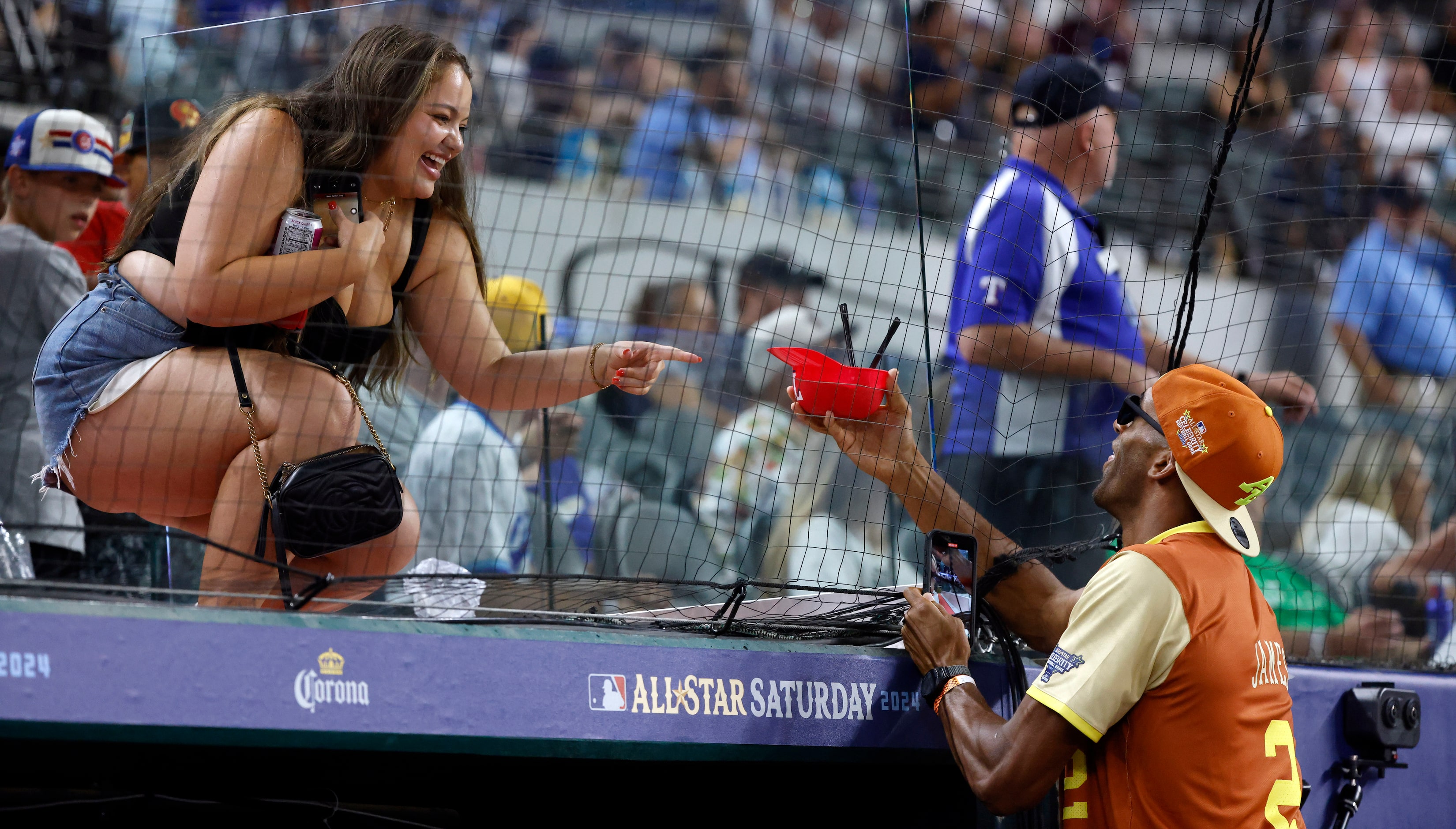 A fan comes down to the dugout with an ice cream for The Bachelor's Matt James during the...