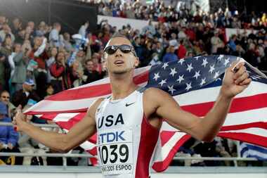 Jeremy Wariner of the U.S. poses with the Stars and Stripes after winning the gold medal in...