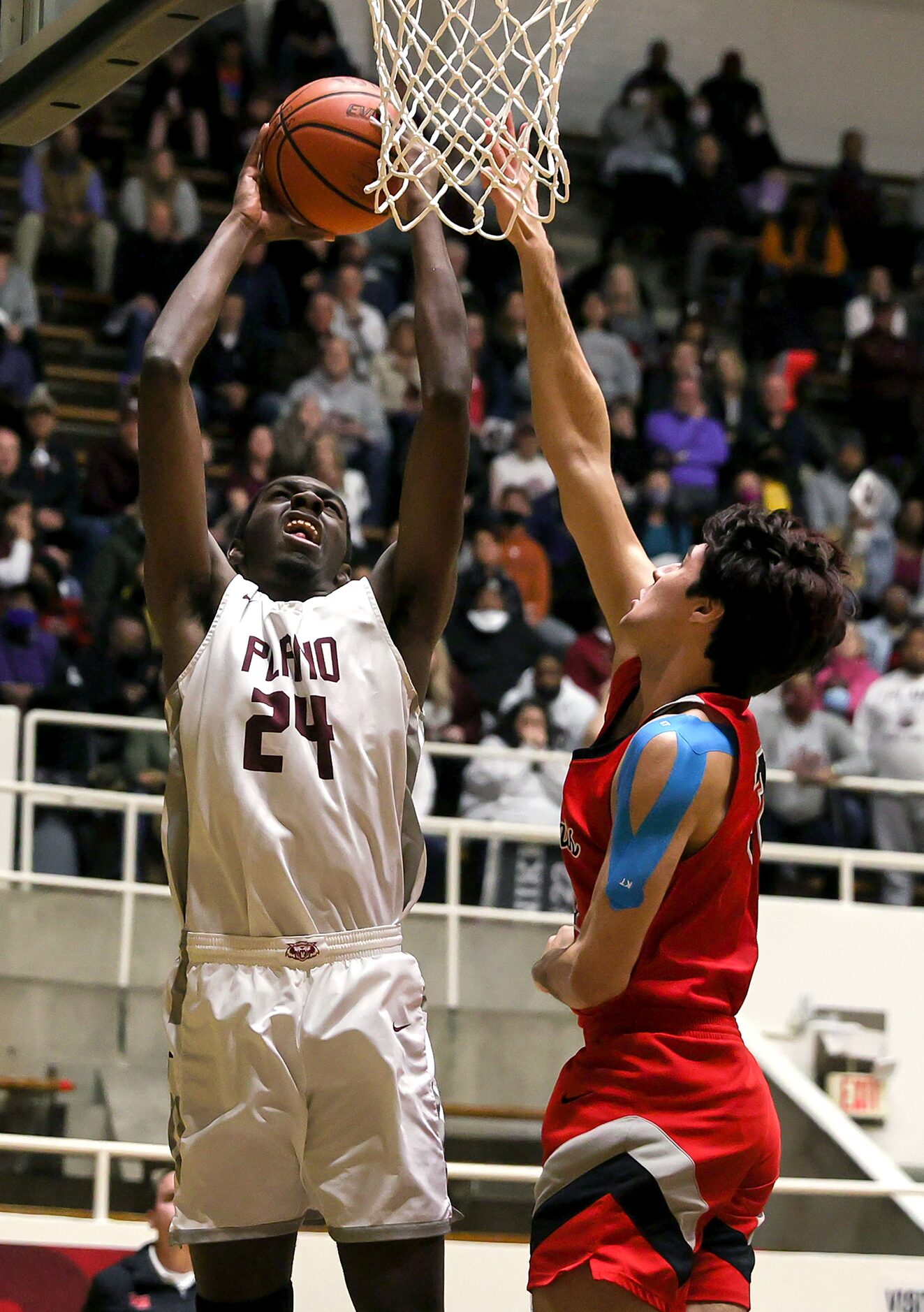 Plano forward Robert Hall (24) attempts a shot over Lake Highland forward Adam Lopez (R)...