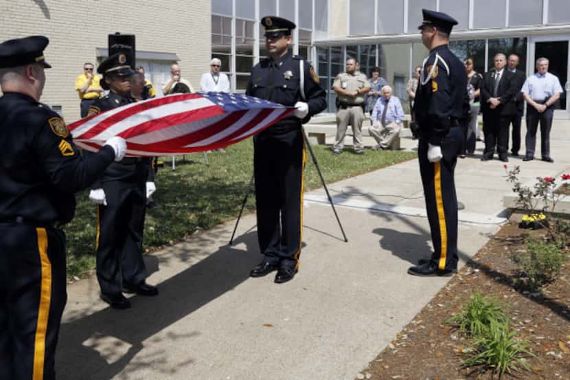 Dallas County Sheriff's Department Honor Guard members fold the U.S. Honor Flag that was...