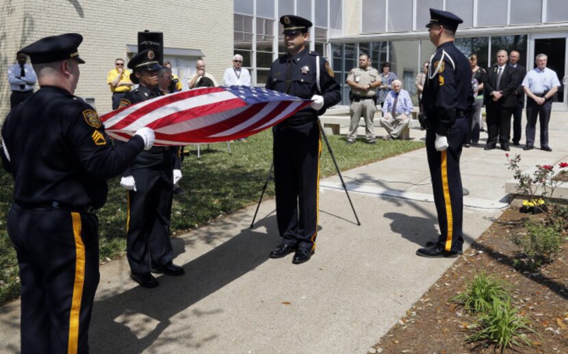 Dallas County Sheriff's Department Honor Guard members fold the U.S. Honor Flag that was...