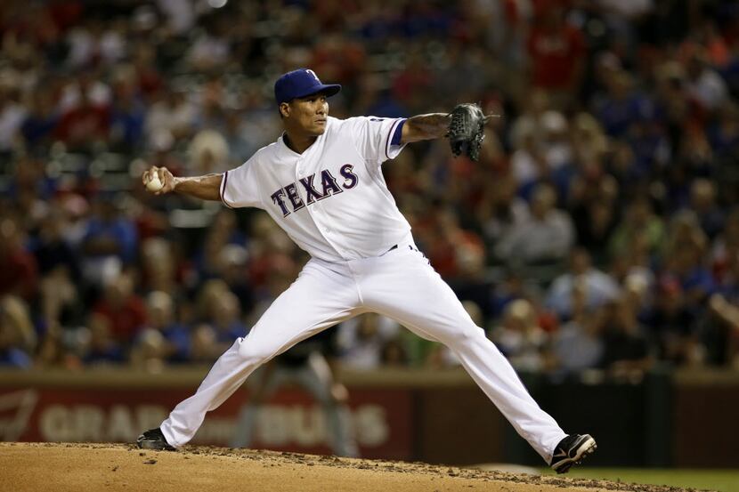 Texas Rangers starting pitcher Alexi Ogando (41) delivers to the Milwaukee Brewers in the...