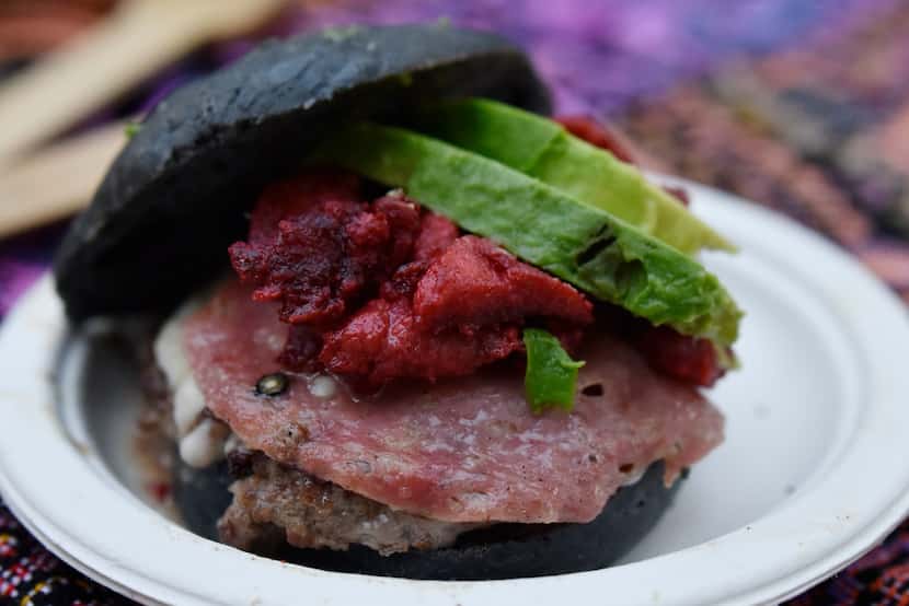 The Trompo Burger Slider layers a beef patty with slices of pork trompo, salami, avocado and...