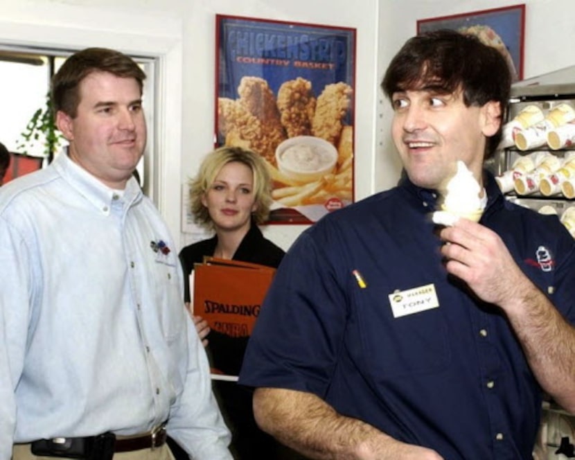 Dallas Mavericks owner Mark Cuban serves up a soft-serve cone to the approval of DQ Manager...