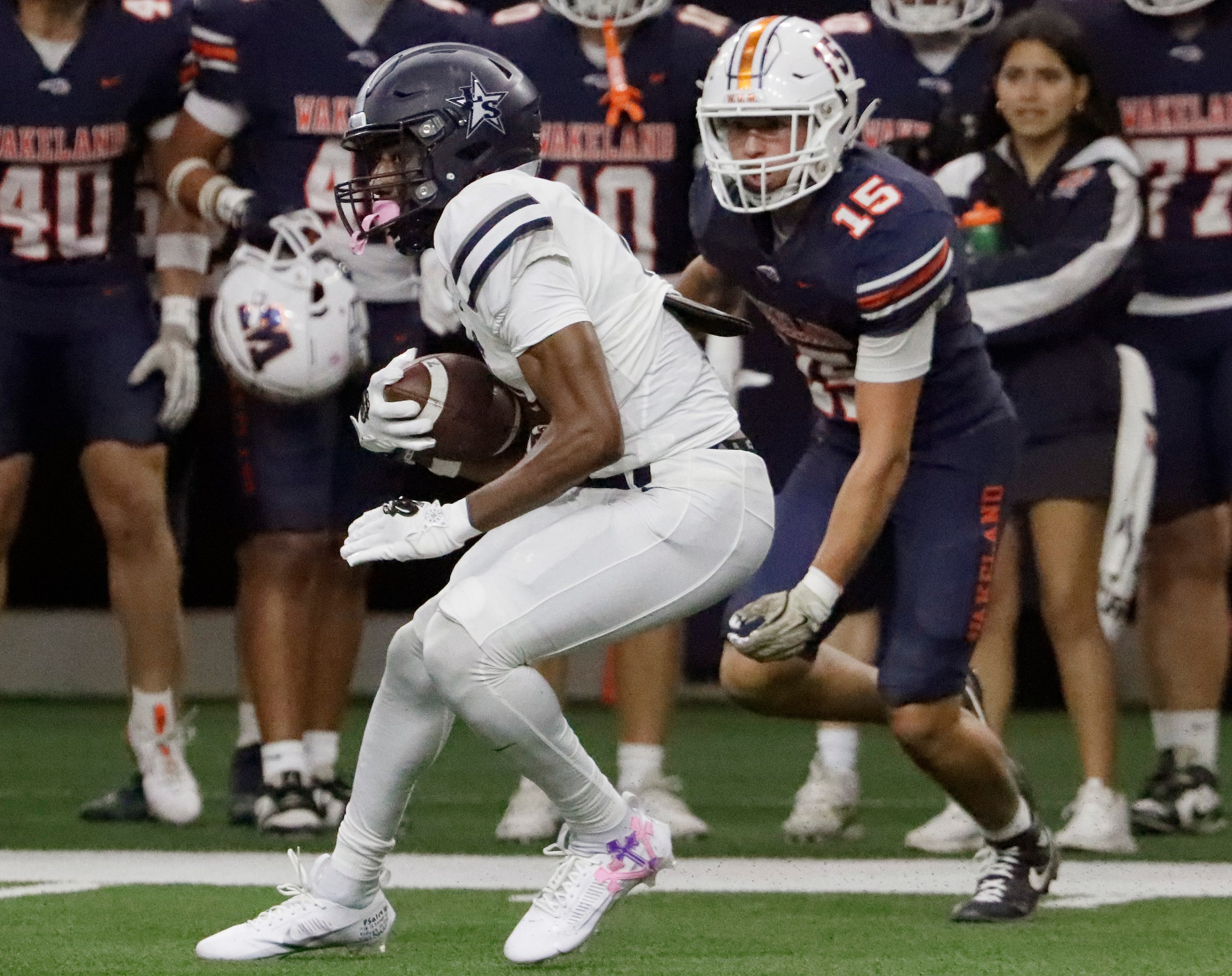 Lone Star High School Davian Groce (0) looks for room to run in front of Wakeland High...