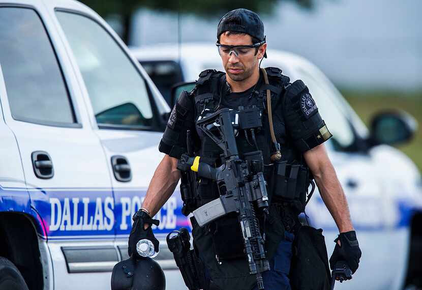  A Dallas SWAT officer who did not want to be identified by name walks to his vehicle at the...