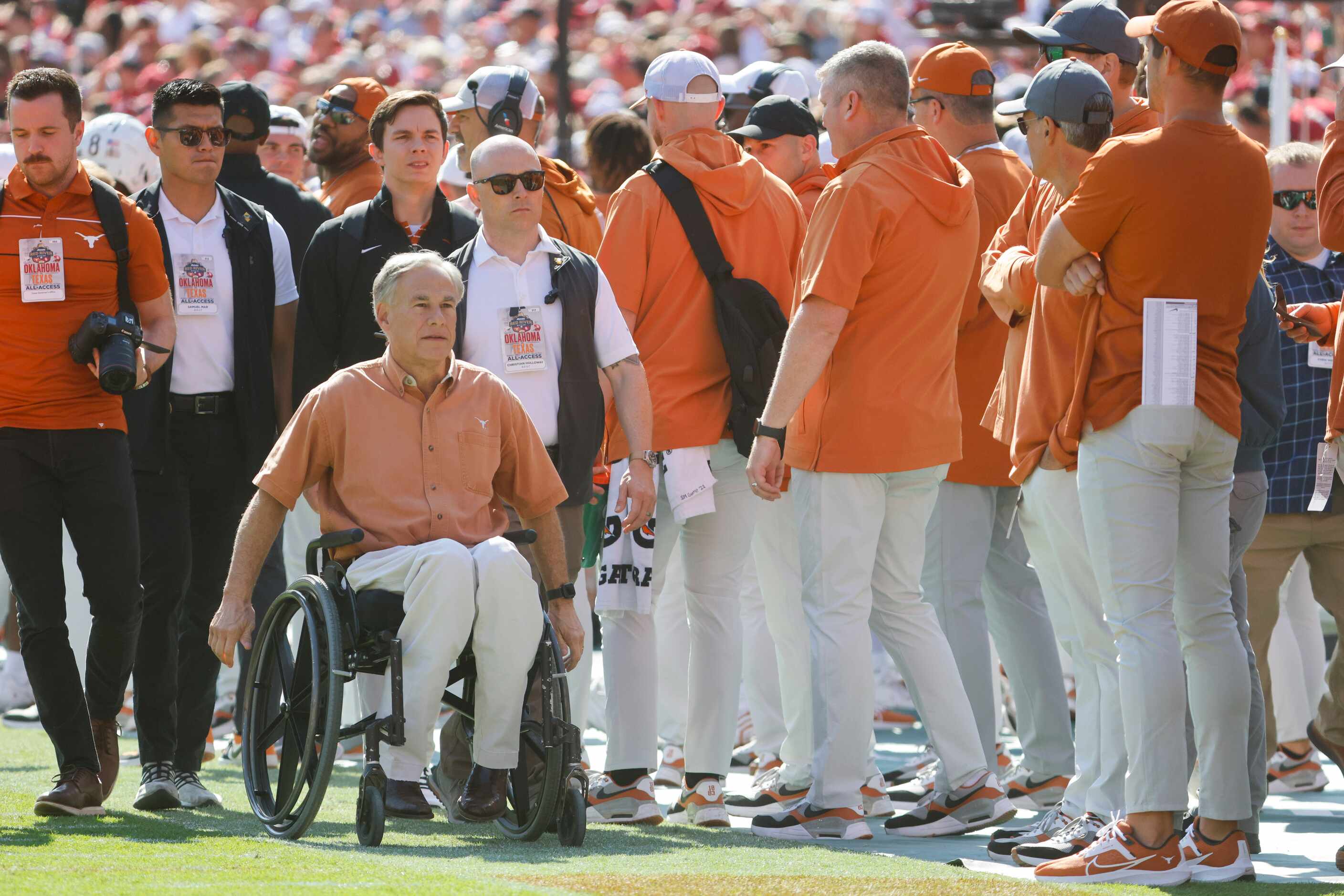 Texas Governor Greg Abbott remains on the field during the Red River Rivalry at the Cotton...