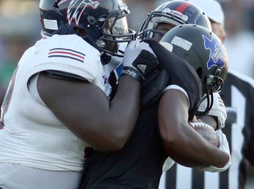 Trinity Christian running back Justin Debashski (3) feels the presence of Bishop Dunne...