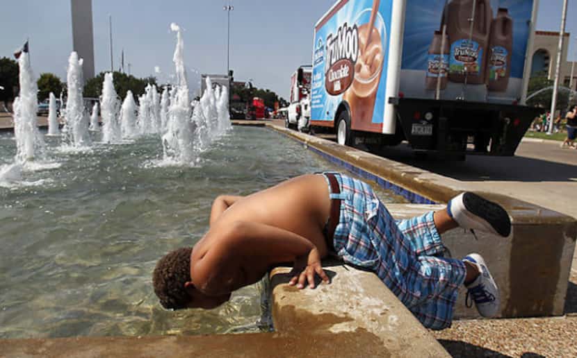 Eight-year-old Coby Vandergriff dunks his head in a Fair Park fountain Thursday after...