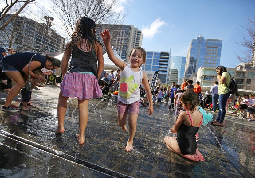Children of all ages enjoy the spray park fountain during  at Klyde Warren Park in downtown...