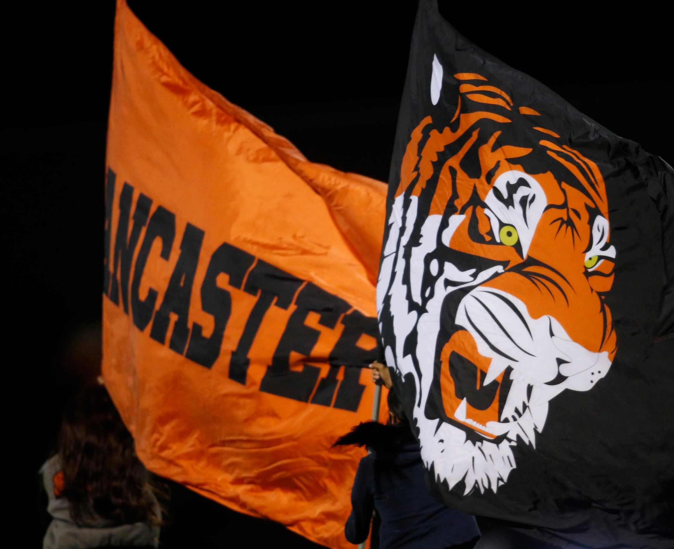 A pair of Lancaster Tigers flag wavers members race across the field following a banner...