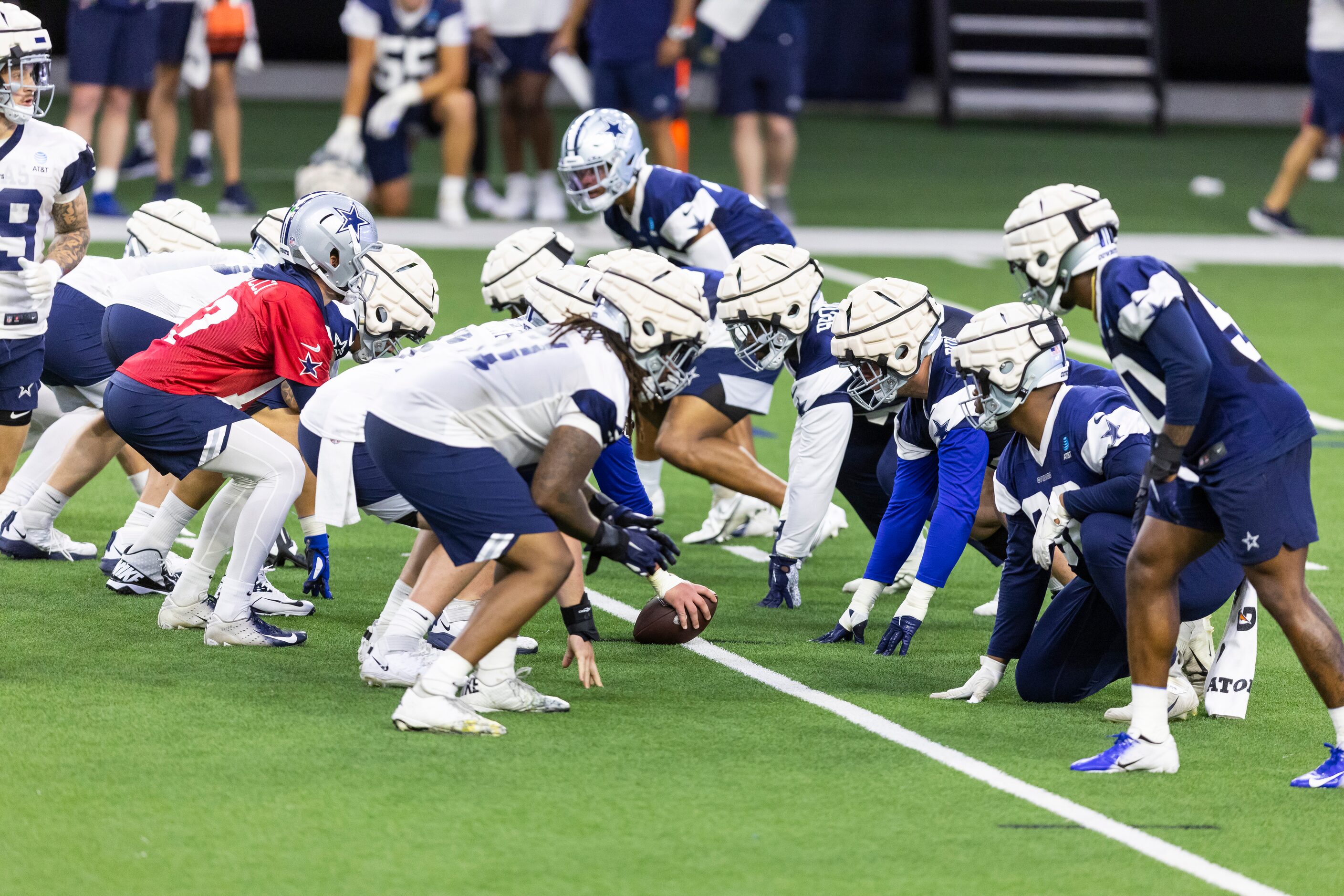 Dallas Cowboys offensive and defensive players wear padded covers on top of their normal...