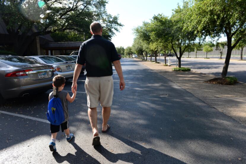 Robert Griffin walks with his son Donovan, 3, to the Brookhaven Country Club, which sits in...