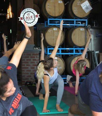 Yoga class takes place in the shadow of beer kegs at Collective Brewing Project in Fort...