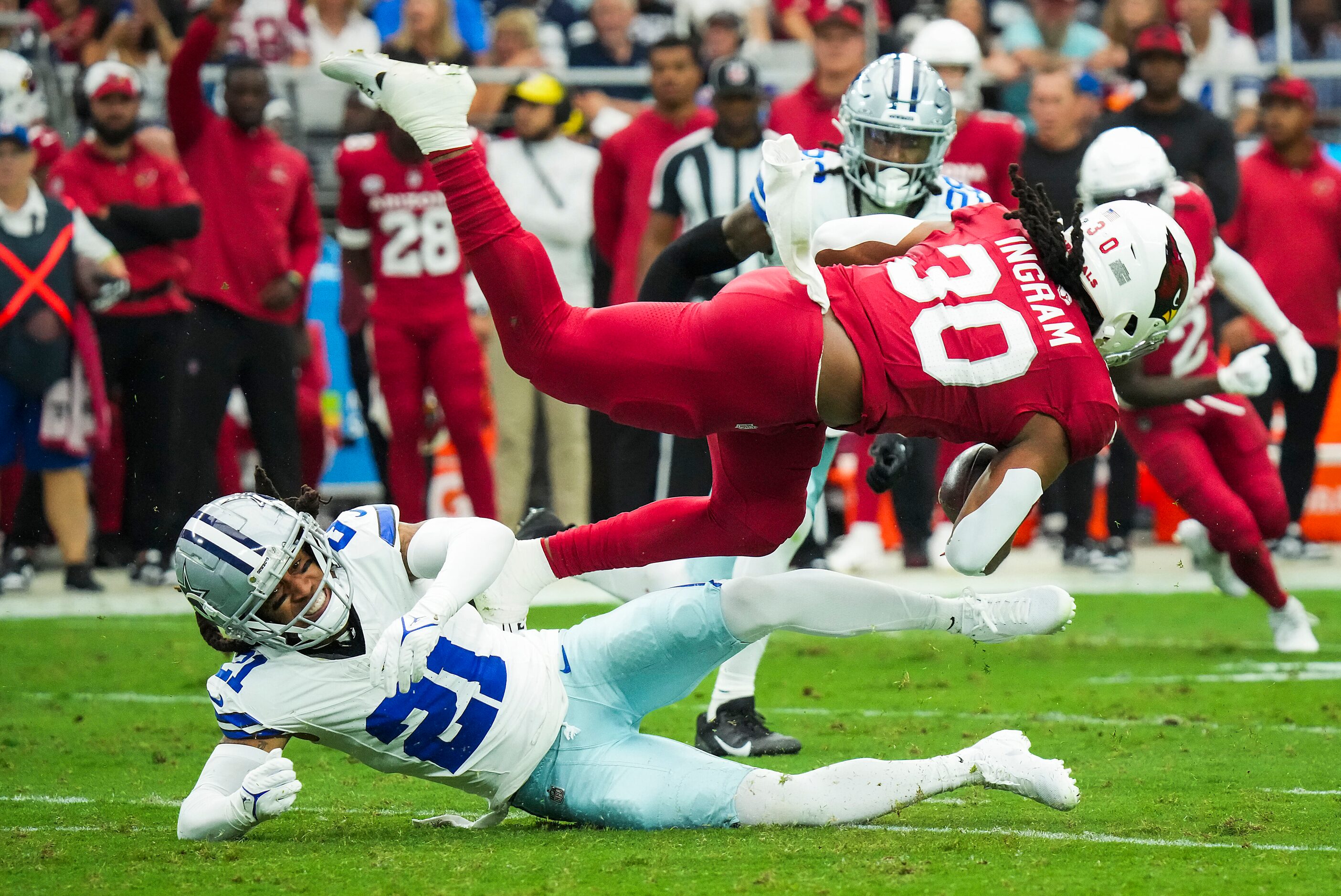 Arizona Cardinals running back Keaontay Ingram (30) is tripped up by Dallas Cowboys...