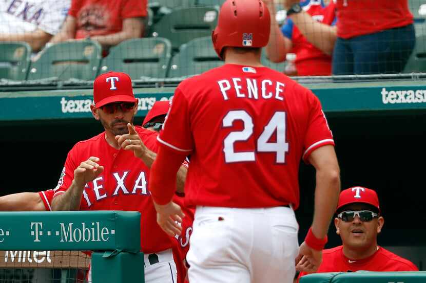 Texas Rangers manager Chris Woodward, left, points to Hunter Pence (24) after Pence scored...