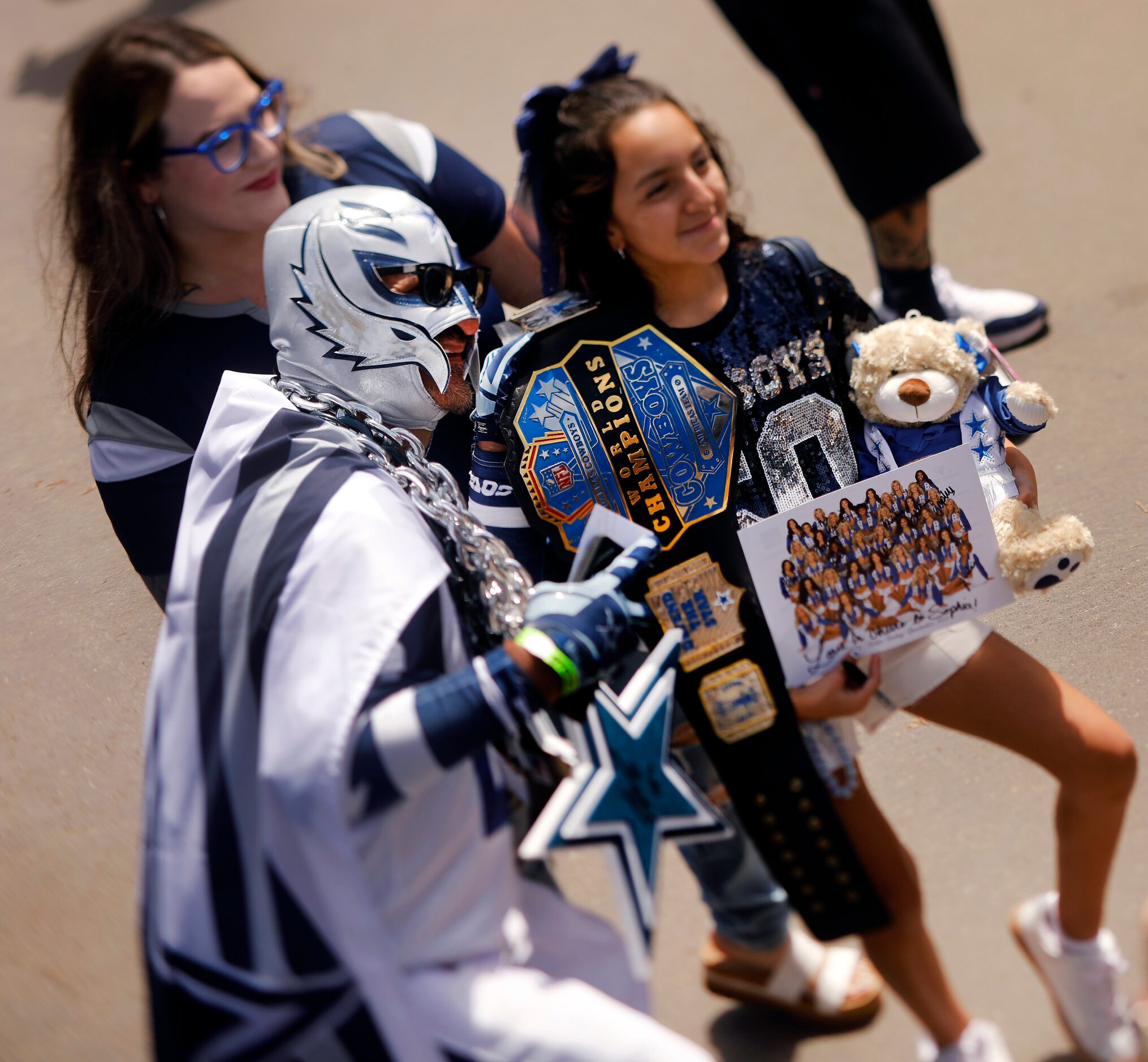 Dallas Cowboys super fan Carlos Santa Cruz of Salinas, California (center) poses for photos...