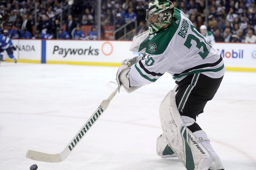 Dallas Stars goaltender Ben Bishop (30) fires a pass that became an assist on a goal by...